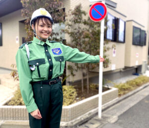 日本興志_笑顔で案内をする女性警備員