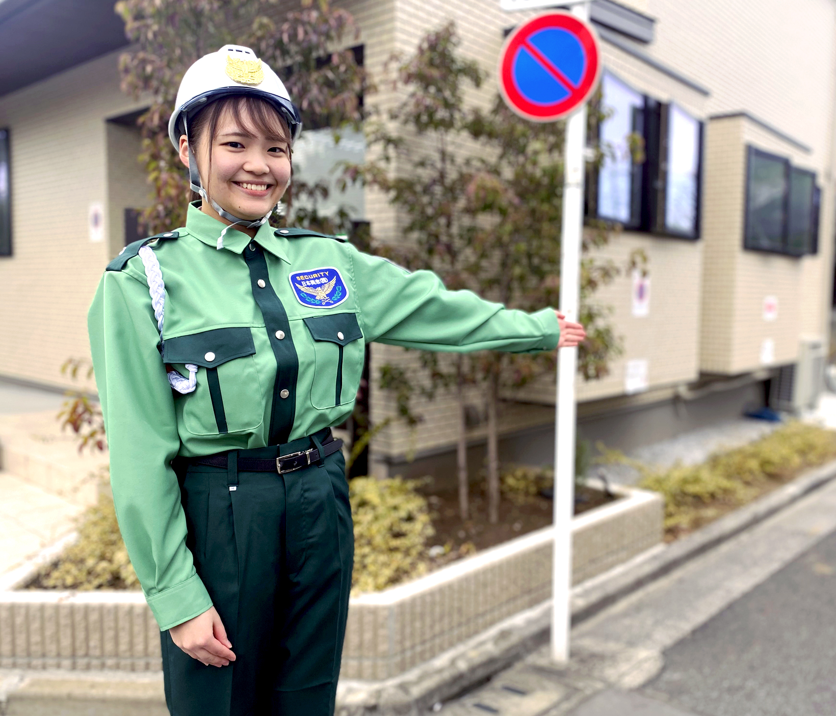 日本興志_笑顔で案内をする女性警備員