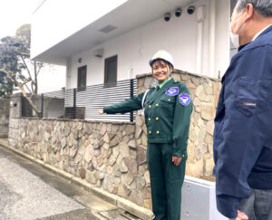 日本興志_笑顔で案内をする女性警備員