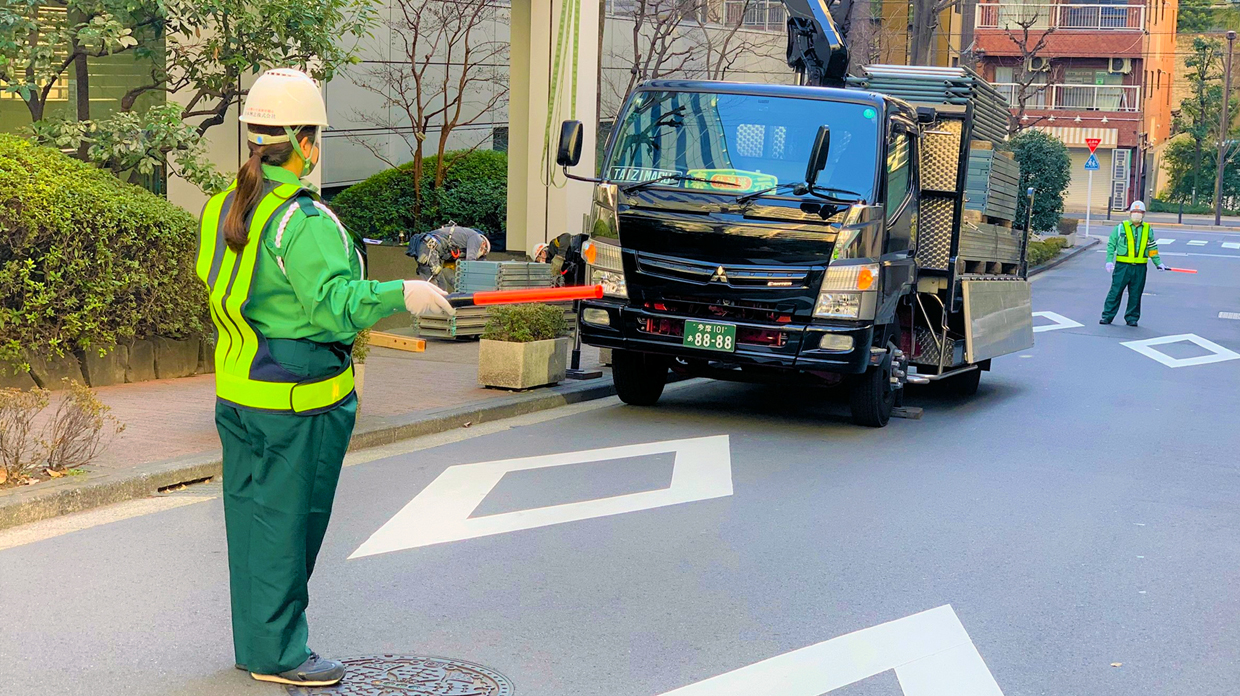 日本興志_警備をしている女性従業員の後ろ姿